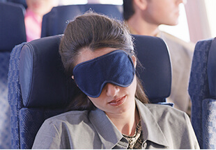在機艙座位戴著眼罩睡覺的女性乘客