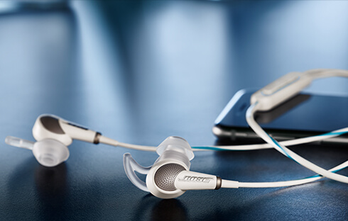 BOSE白色有線耳機放置在桌上連接著手機