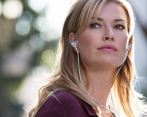 用有線耳機聽音樂的金髮外國女性